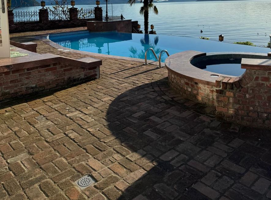 Beautiful outdoor brick paver patio surrounding pool with scenic waterfront view - professional Vancouver paving installation