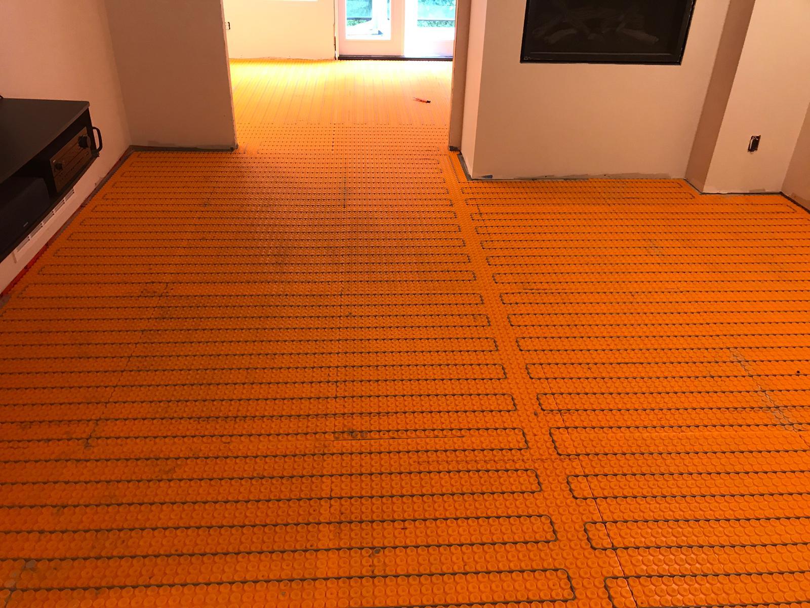 In-floor radiant heating system installation under tile in Vancouver home showing electric and hydronic setup